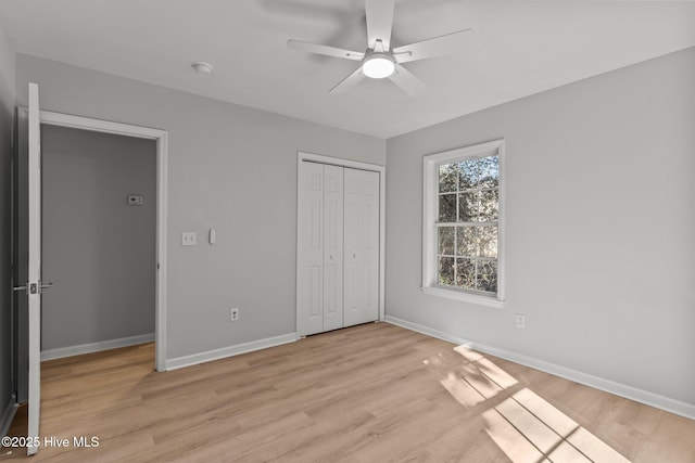 unfurnished bedroom with light hardwood / wood-style flooring, a closet, and ceiling fan