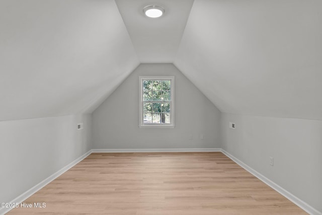 additional living space featuring lofted ceiling and light hardwood / wood-style flooring