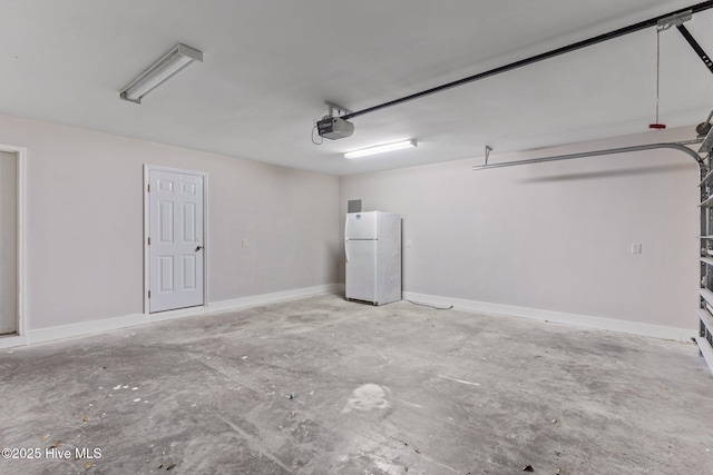 garage with a garage door opener and white fridge