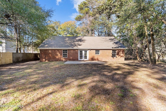 rear view of property with french doors, a lawn, and a patio area