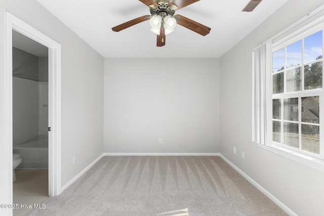 carpeted spare room featuring ceiling fan