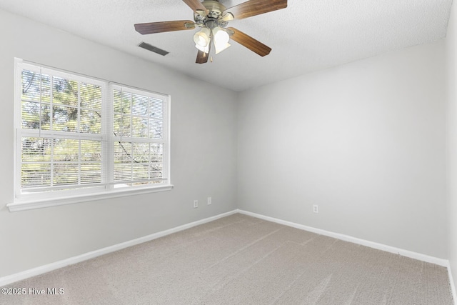 spare room featuring ceiling fan, carpet flooring, and a textured ceiling