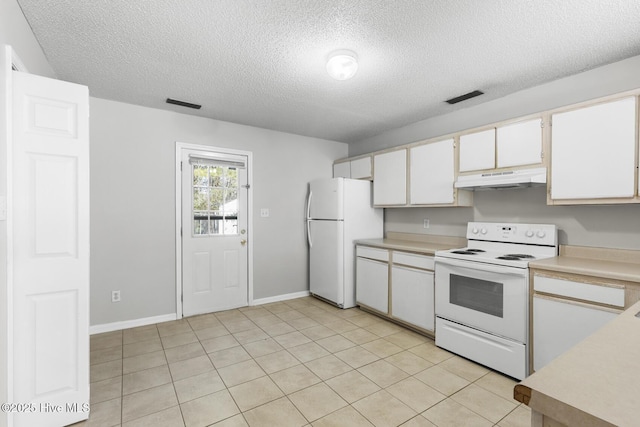 kitchen with white appliances, light tile patterned floors, a textured ceiling, and white cabinets