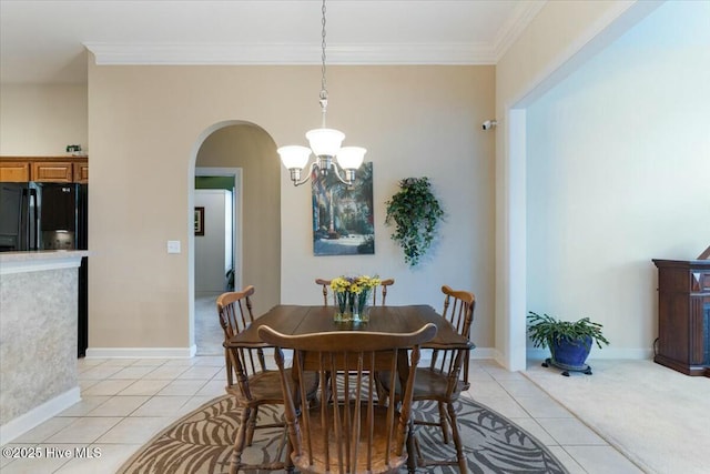 dining room with light tile patterned flooring, ornamental molding, and a chandelier