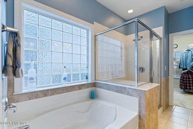 bathroom with plus walk in shower, a healthy amount of sunlight, and tile patterned floors