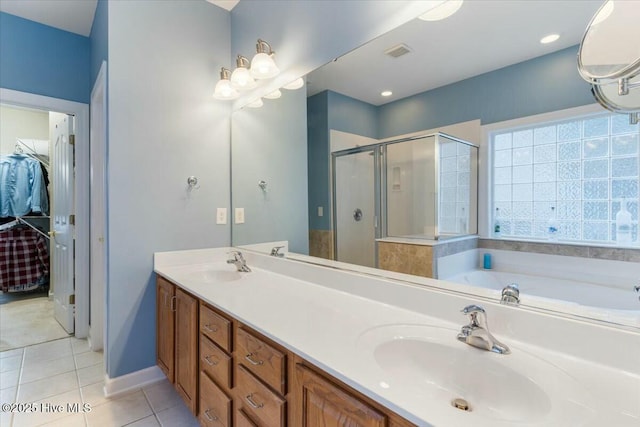 bathroom with tile patterned flooring, vanity, and separate shower and tub