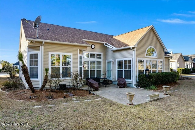 back of house with a patio area and a lawn