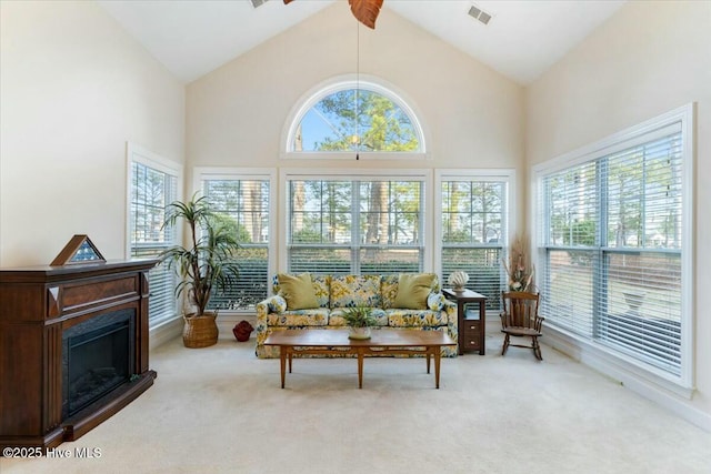 sunroom / solarium with ceiling fan, a healthy amount of sunlight, and vaulted ceiling