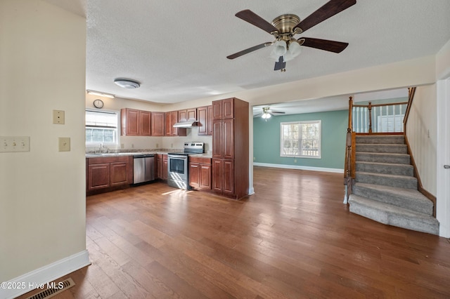 kitchen featuring sink, dark wood-type flooring, ceiling fan, stainless steel appliances, and a textured ceiling