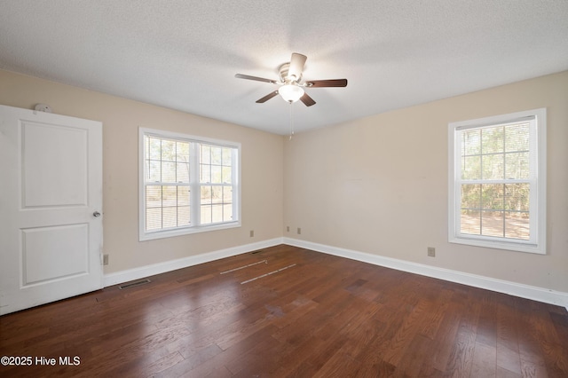 empty room with ceiling fan, dark wood-type flooring, and a textured ceiling