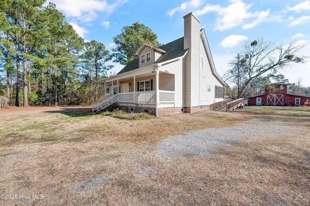 view of side of home with a porch and a yard