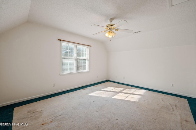 additional living space featuring lofted ceiling, ceiling fan, carpet floors, and a textured ceiling