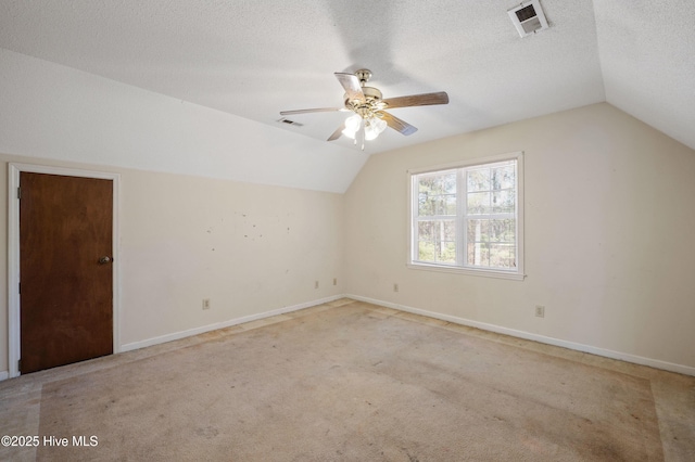 bonus room with vaulted ceiling, light carpet, ceiling fan, and a textured ceiling