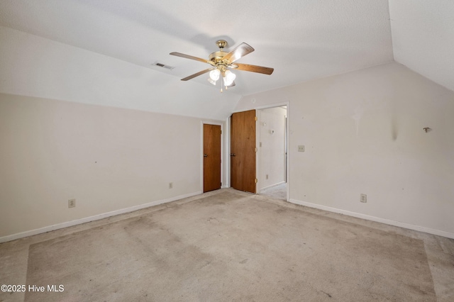 interior space featuring vaulted ceiling, light carpet, and ceiling fan