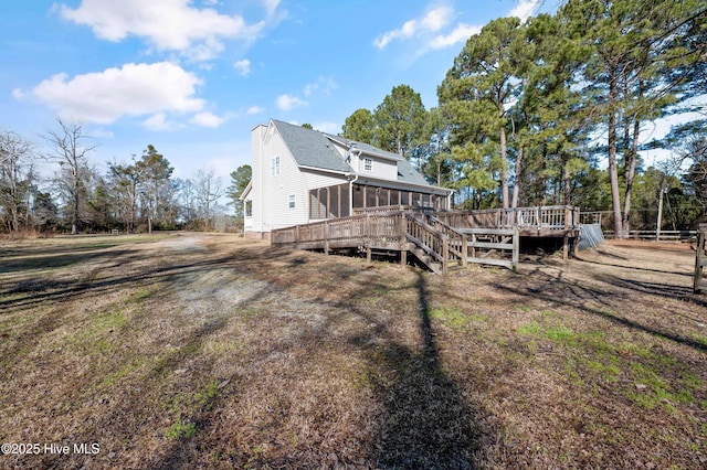 back of property with a deck and a sunroom