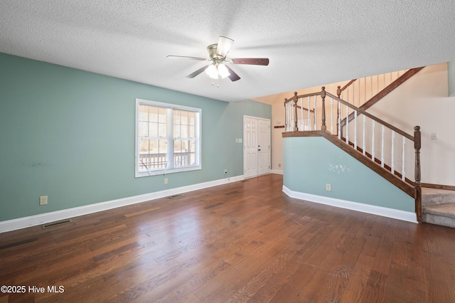 unfurnished living room featuring ceiling fan, dark hardwood / wood-style flooring, and a textured ceiling