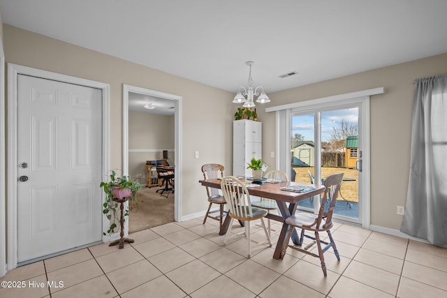 dining space featuring light tile patterned flooring and an inviting chandelier