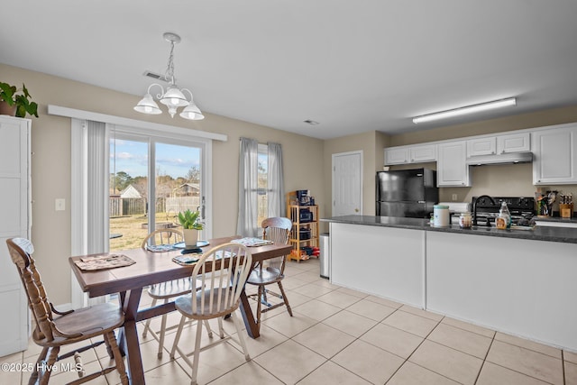 kitchen featuring sink, black appliances, light tile patterned floors, pendant lighting, and white cabinets