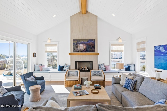 living room featuring high vaulted ceiling, a large fireplace, hardwood / wood-style floors, and beam ceiling