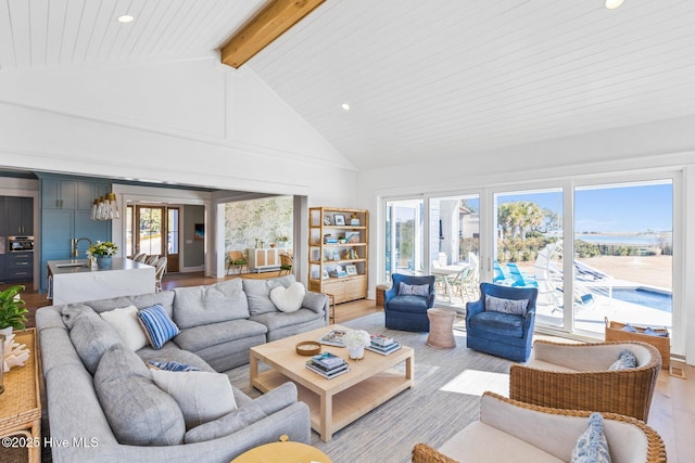 living room featuring beamed ceiling, sink, high vaulted ceiling, and light hardwood / wood-style flooring