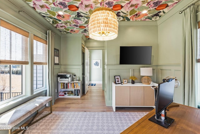 interior space with light hardwood / wood-style flooring, crown molding, and plenty of natural light