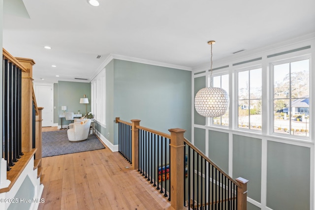 hall with crown molding and light hardwood / wood-style flooring