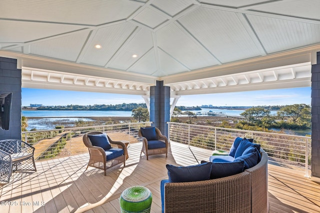 wooden deck featuring an outdoor living space and a water view