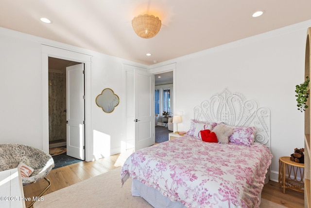 bedroom with hardwood / wood-style flooring and ensuite bathroom