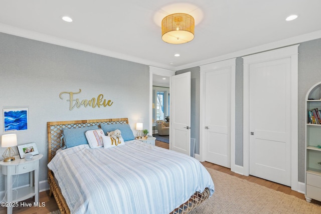 bedroom with ornamental molding and wood-type flooring