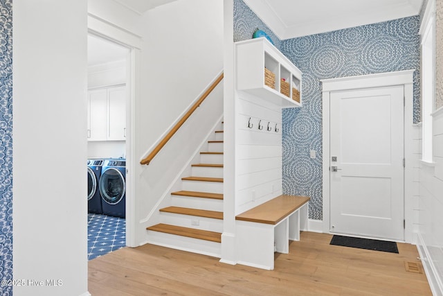 mudroom featuring crown molding, separate washer and dryer, and light hardwood / wood-style floors