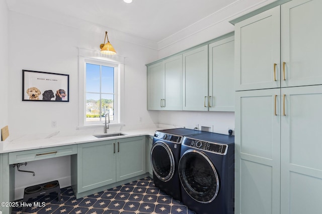 laundry room featuring crown molding, cabinets, washer and clothes dryer, and sink