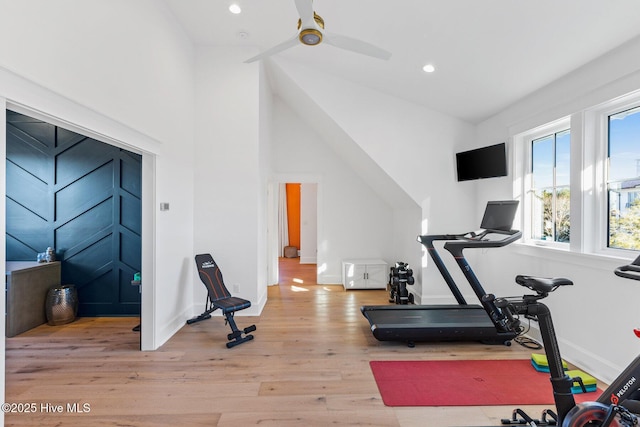 workout room featuring lofted ceiling and light wood-type flooring