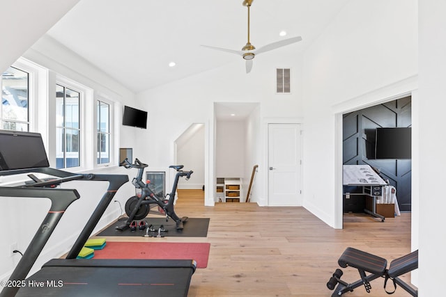 exercise room with wood-type flooring, high vaulted ceiling, and ceiling fan