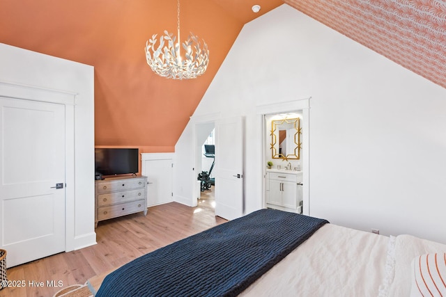 bedroom featuring vaulted ceiling, an inviting chandelier, sink, and light hardwood / wood-style floors