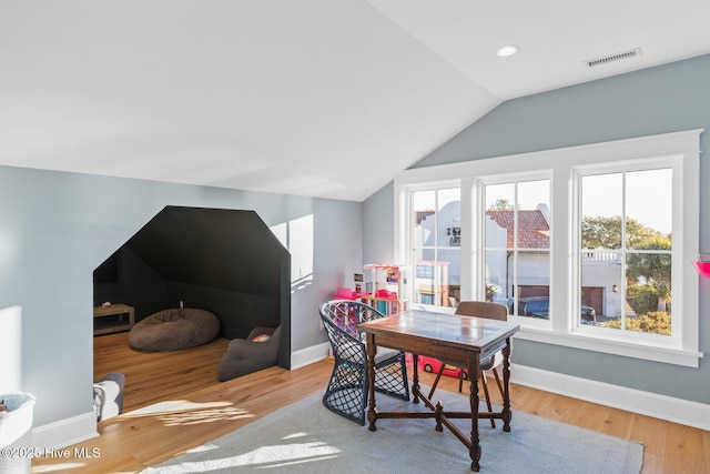 dining space with vaulted ceiling and light wood-type flooring