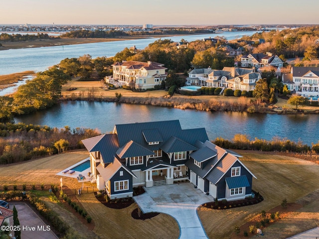 aerial view at dusk featuring a water view