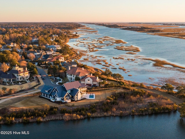 aerial view at dusk featuring a water view