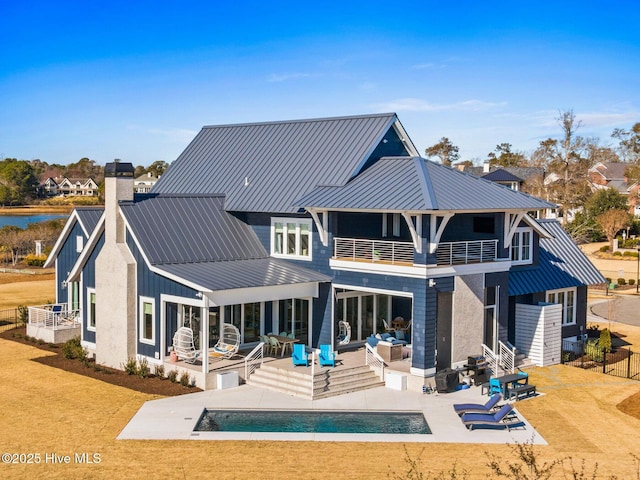 rear view of property with a patio area, outdoor lounge area, a balcony, and a lawn