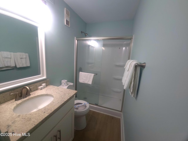 bathroom featuring walk in shower, vanity, toilet, and hardwood / wood-style flooring