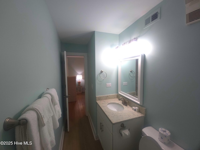 bathroom with vanity, wood-type flooring, and toilet