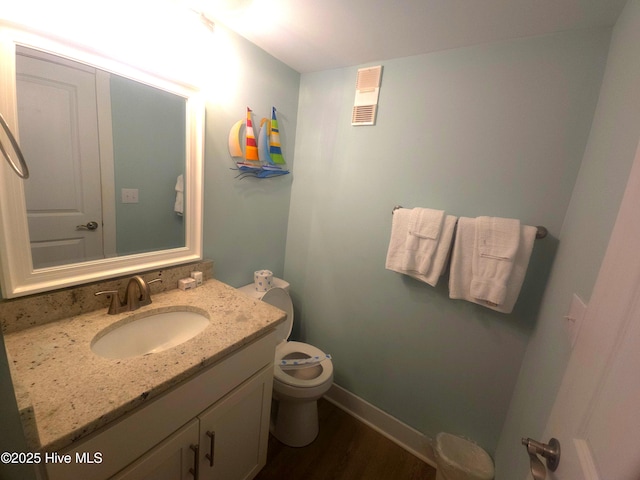 bathroom featuring vanity, wood-type flooring, and toilet