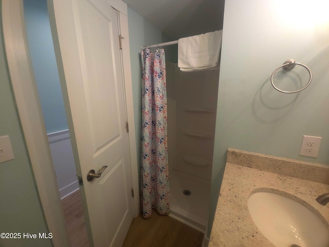 bathroom with hardwood / wood-style flooring, sink, and a shower with curtain