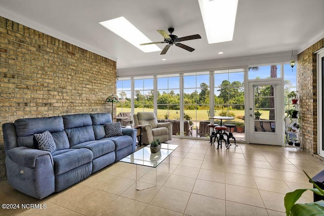 sunroom / solarium featuring a wealth of natural light, a skylight, and ceiling fan