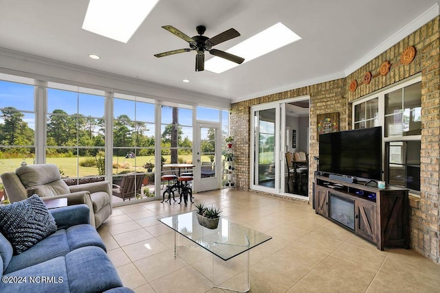 living room featuring crown molding, brick wall, light tile patterned floors, and a skylight