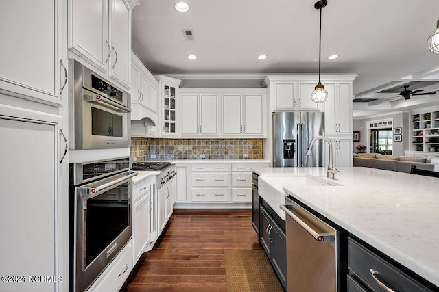 kitchen with pendant lighting, stainless steel appliances, dark hardwood / wood-style floors, and white cabinets