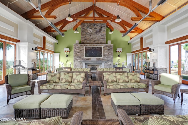 living room featuring wood ceiling, beam ceiling, a fireplace, and high vaulted ceiling