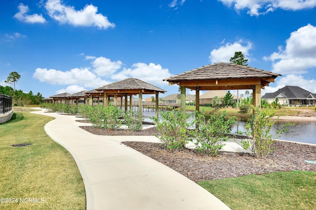 surrounding community with a gazebo, a water view, and a yard