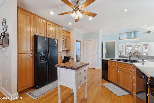 kitchen with butcher block countertops, black appliances, sink, ceiling fan, and light hardwood / wood-style floors