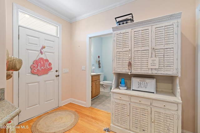 foyer entrance featuring ornamental molding and light wood-type flooring