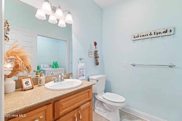 bathroom featuring vanity, toilet, and washer / dryer